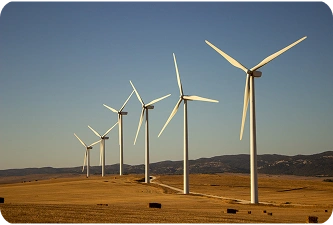 Moderne windmolenpark met meerdere turbines die schone elektriciteit opwekken over een open landschap, wat de ontwikkeling van hernieuwbare energie vertegenwoordigt.