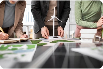 Professionals werken samen aan ontwerpen voor windenergieprojecten met behulp van schaalmodellen en planningsmaterialen voor hernieuwbare infrastructuur.
